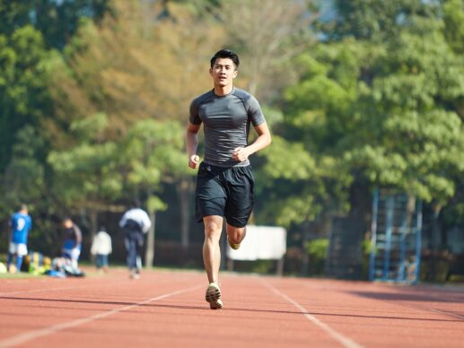 Young asian male running on a running track