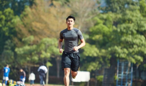 Young asian male running on a running track