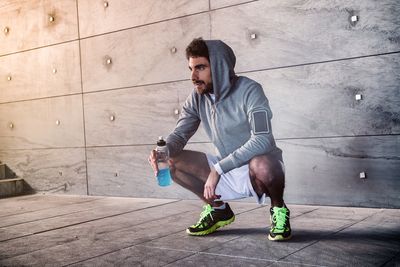 Athlete crouched with a sport drink